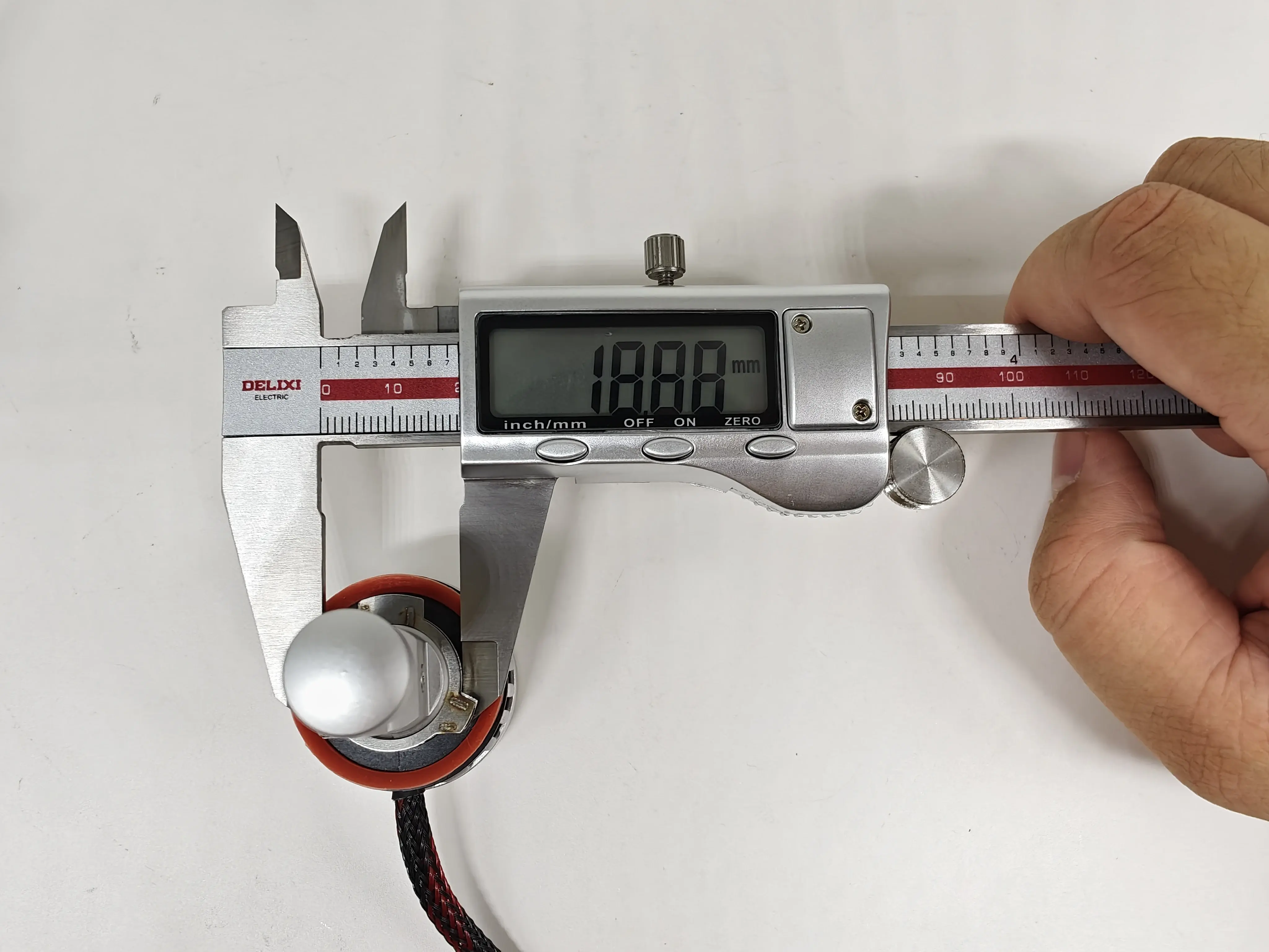 Outer-diameter measurement of the EB H11 LEDr base locating section with the digital caliper reading oriented for normal reading